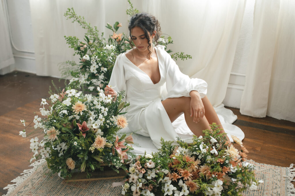 bride posing with flowers at the mill studio