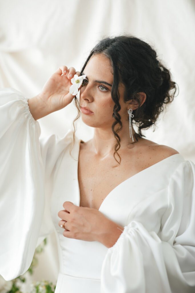 bride posing with dogwood flower photographed by asheville wedding photographer